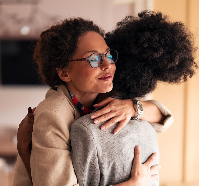 Two women hugging each other