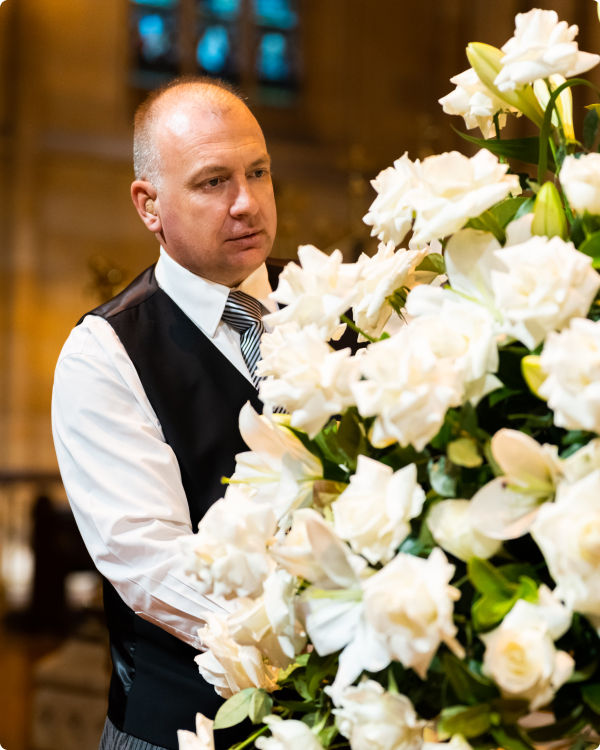 funeral director arranging floweres